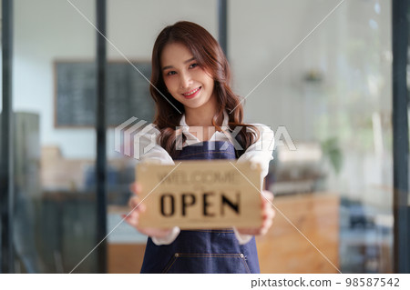 Beautiful female manager in restaurant with tablet. Man coffee shop owner with open sign. Small business concept 98587542
