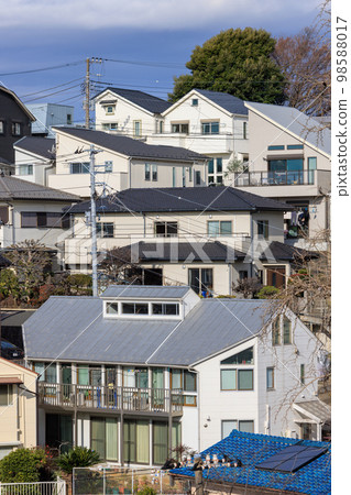 A white detached house built on a hillside 98588017