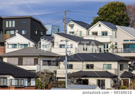 A white detached house built on a hillside 98588018