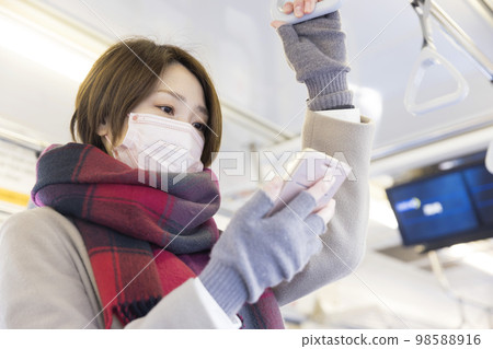 戴口罩的中年婦女穿著冬裝乘火車 戴口罩的中年婦女穿著冬裝乘火車 98588916
