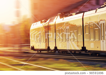 Passenger train moving along railway in sunset in summer. 98591896