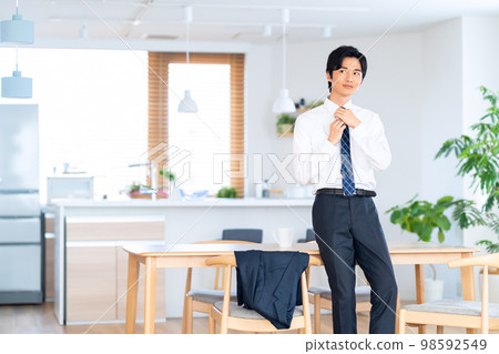 Male morning commute living room businessman changing clothes 98592549