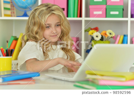 girl using laptop at desk at home 98592596