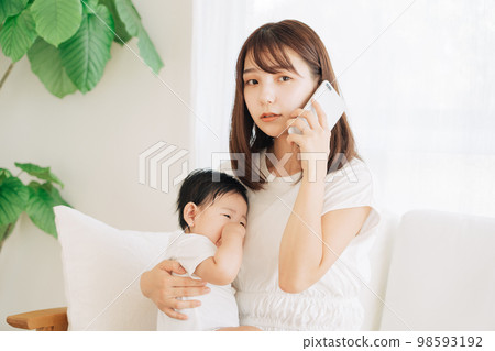 Mother calling the hospital with her sick baby 98593192