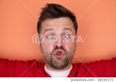 Shocked unshaven man expressing surprise on camera isolated over gray background Shocked unshaven man expressing surprise on camera isolated over gray background 98595575