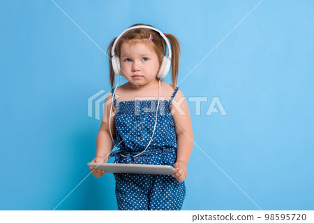 Beautiful cute happy little girl with headphones 98595720