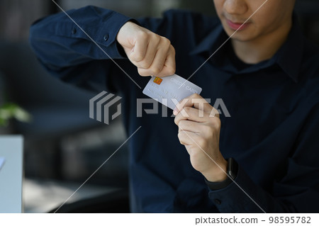 Close up view of man solving his problems by destroying his credit card. Bankruptcy, financial problems concept Close up view of man solving his problems by destroying his credit card. Bankruptcy, financial problems concept 98595782