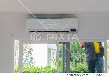 Technician install air conditioner on the wall 98596510