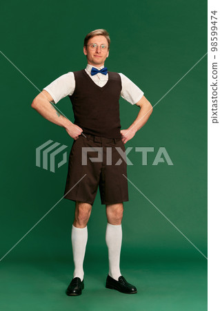 Gentleman look. Portrait of man in stylish classical clothes posing over green studio background. Concept of emotions, facial expression, lifestyle 98599474