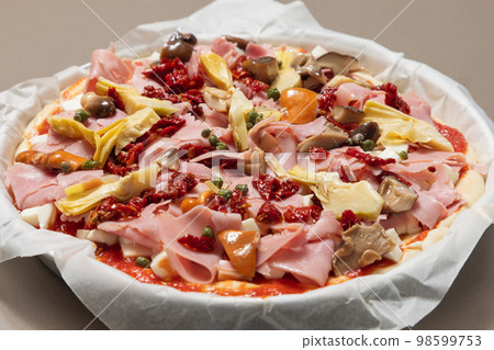 Uncooked homemade Italian pizza capricciosa with classic ingredients ready for baking 98599753
