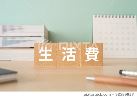 A desk with a block that says cost of living A desk with a block that says cost of living 98599937