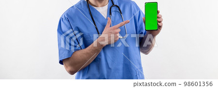 Doctor nurse in uniform and with a stethoscope points to a smartphone with a green screen advertising medical pharmacology  98601356