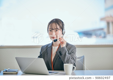 Young woman answering the phone in the office 98602497