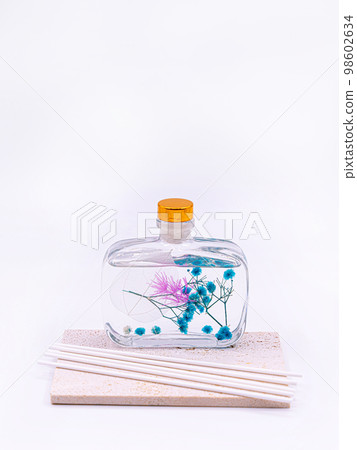 Wooden aroma sticks in a glass flask filled with flavor liquid substance isolated over white background, side view  98602634