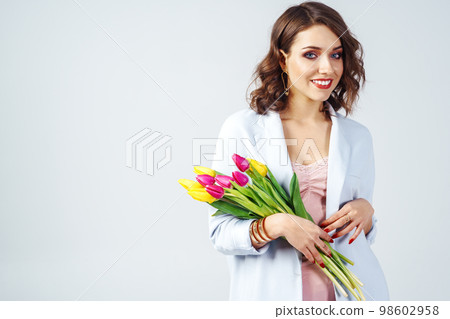 Fashion photo of beautiful woman with tulips in her hand March 8. beautiful girl in stylish clothes 98602958