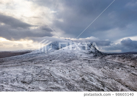 Aerial view of the snow covered Mount Errigal, the highest mountain in Donegal - Ireland. 98603140
