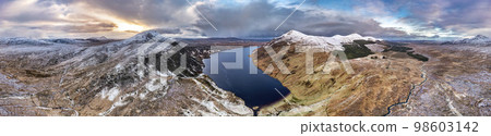 Aerial view of Altan Lough next to the the snow covered Mount Errigal, the highest mountain in Donegal - Ireland. Aerial view of Altan Lough next to the the snow covered Mount Errigal, the highest mountain in Donegal - Ireland. 98603142