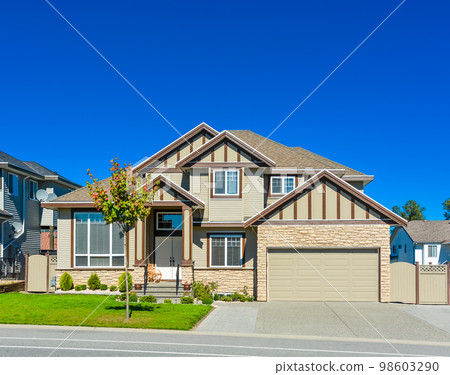 Big family house with concrete driveway and wide garage door Big family house with concrete driveway and wide garage door 98603290