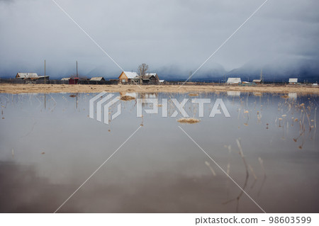 A village in thick fog in the mountains 98603599
