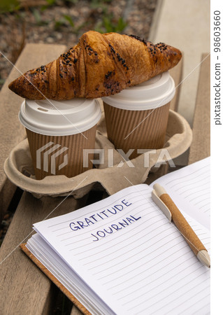 Writing Gratitude Journal on wooden bench. Coffee and croissants morning routine. Today I am grateful for. Self discovery journal, self reflection creative writing, self growth personal development Writing Gratitude Journal on wooden bench. Coffee and croissants morning routine. Today I am grateful for. Self discovery journal, self reflection creative writing, self growth personal development 98603660