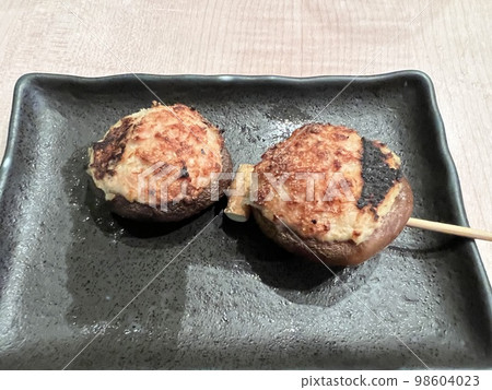 Yakitori of delicious-looking meatballs served on a black plate Yakitori of delicious-looking meatballs served on a black plate 98604023