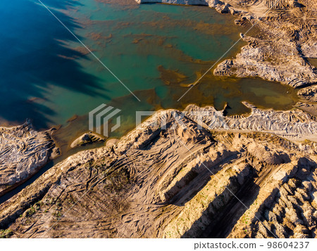 Aerial view of the landscape of a partially flooded sand pit Aerial view of the landscape of a partially flooded sand pit 98604237