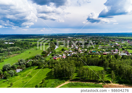 Panoramic aerial view of a rural landscape with green fields Panoramic aerial view of a rural landscape with green fields 98604276
