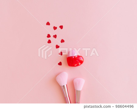 Pink valentines day background with hearts, cosmetics brushes, lipstick on pink background. Pink valentines day background with hearts, cosmetics brushes, lipstick on pink background. 98604496