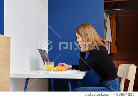 Woman watches tutorial video about cooking Woman watches tutorial video about cooking 98604825