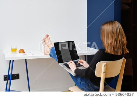 Unrecognizable woman filling application form sitting in rental apartment 98604827