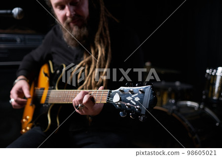 Guitarist man plays an electric guitar Close-up at studio 98605021