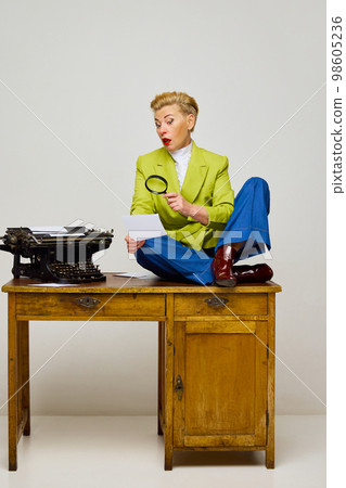 Business woman, journalist. Fashionable middle age blonde woman with short haircut in stylish clothes among retro interior objects over light background. 98605236
