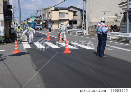 Pedestrian crosswalk white line work in summer 98605335