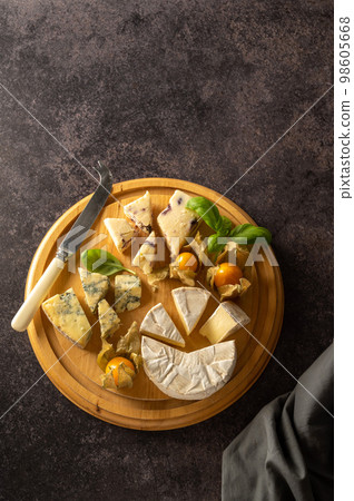 Top view cheese board with blue cheese, cheddar and fruit cheese. Dark background Top view cheese board with blue cheese, cheddar and fruit cheese. Dark background 98605668