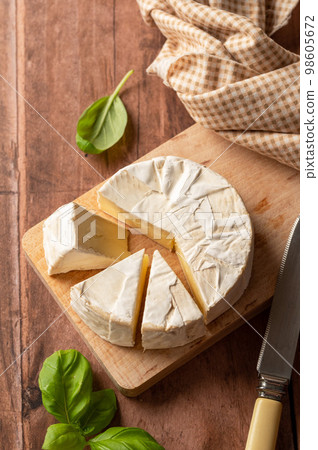 Brie, soft cheese on cutting board. Cheese board. Top view Brie, soft cheese on cutting board. Cheese board. Top view 98605672