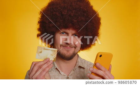 Young man using credit bank card and smartphone while transferring money, purchases online shopping Young man using credit bank card and smartphone while transferring money, purchases online shopping 98605870