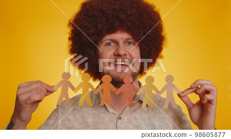 Hipster man showing multiracial different skin color human shape cut out of paper, against racism 98605877