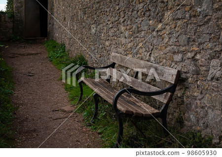a teak hardwood wooden bench on the lawn in the UK winter a teak hardwood wooden bench on the lawn in the UK winter 98605930