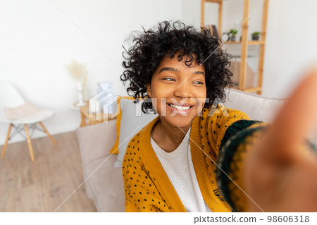 Happy african american teen girl blogger smiling face talking to webcam recording vlog. Social media influencer woman streaming making video call at home. Headshot portrait selfie webcamera view 98606318