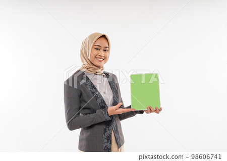 a woman with hijab standing and showing the tablet at her hand 98606741