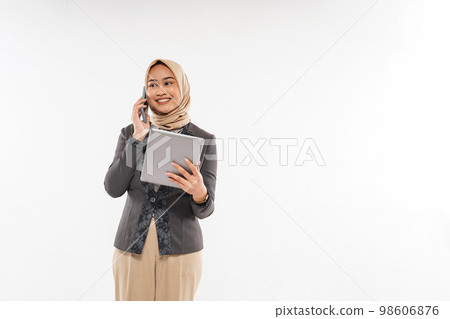 a young woman with hijab standing and calling someone on phone 98606876