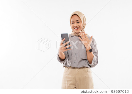 woman with hijab standing with hand opened while looking at her phone woman with hijab standing with hand opened while looking at her phone 98607013
