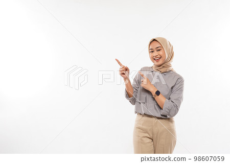 woman with hijab excitedly pointing on the empty space at her side woman with hijab excitedly pointing on the empty space at her side 98607059