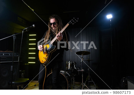 Guitarist man plays an electric guitar Close-up at studio Guitarist man plays an electric guitar Close-up at studio 98607173