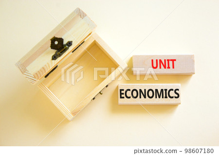 Unit economics symbol. Concept words Unit economics on wooden blocks. Beautiful white table white background. Wooden empthy chest. Business and unit economics concept. Copy space. Unit economics symbol. Concept words Unit economics on wooden blocks. Beautiful white table white background. Wooden empthy chest. Business and unit economics concept. Copy space. 98607180