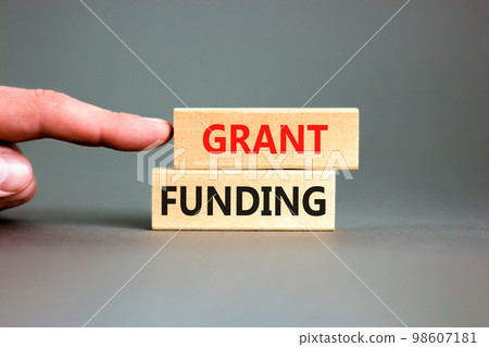 Grant funding symbol. Concept words Grant funding on wooden blocks. Beautiful grey table grey background. Businessman hand. Business and grant funding concept. Copy space. Grant funding symbol. Concept words Grant funding on wooden blocks. Beautiful grey table grey background. Businessman hand. Business and grant funding concept. Copy space. 98607181