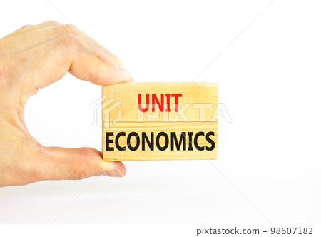 Unit economics symbol. Concept words Unit economics on wooden blocks. Beautiful white table white background. Businessman hand. Business and unit economics concept. Copy space. Unit economics symbol. Concept words Unit economics on wooden blocks. Beautiful white table white background. Businessman hand. Business and unit economics concept. Copy space. 98607182