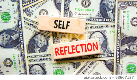 Self reflection symbol. Concept word Self reflection typed on wooden blocks. Beautiful background from dollar bills. Business psychological and self reflection concept. Copy space. 98607187