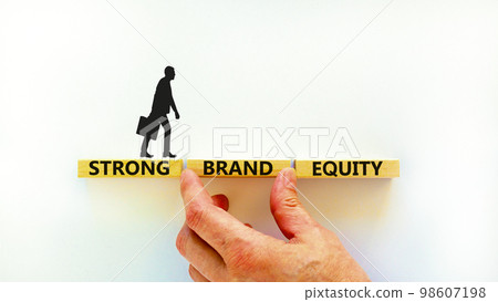Strong brand equity symbol. Concept words Strong brand equity on wooden blocks on a beautiful white table white background. Businessman hand. Business, finacial and strong brand equity concept. Strong brand equity symbol. Concept words Strong brand equity on wooden blocks on a beautiful white table white background. Businessman hand. Business, finacial and strong brand equity concept. 98607198
