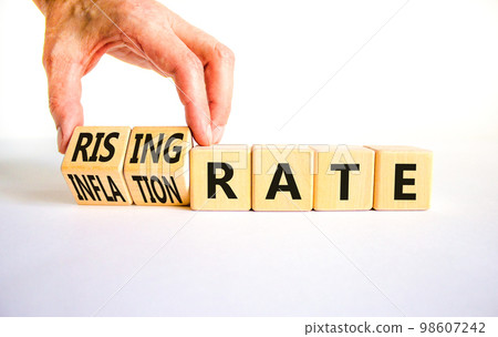 Inflation or rising rate symbol. Concept word Inflation rate Rising rate on wooden cubes. Businessman hand. Beautiful white table white background. Business inflation rising rate concept. Copy space. 98607242